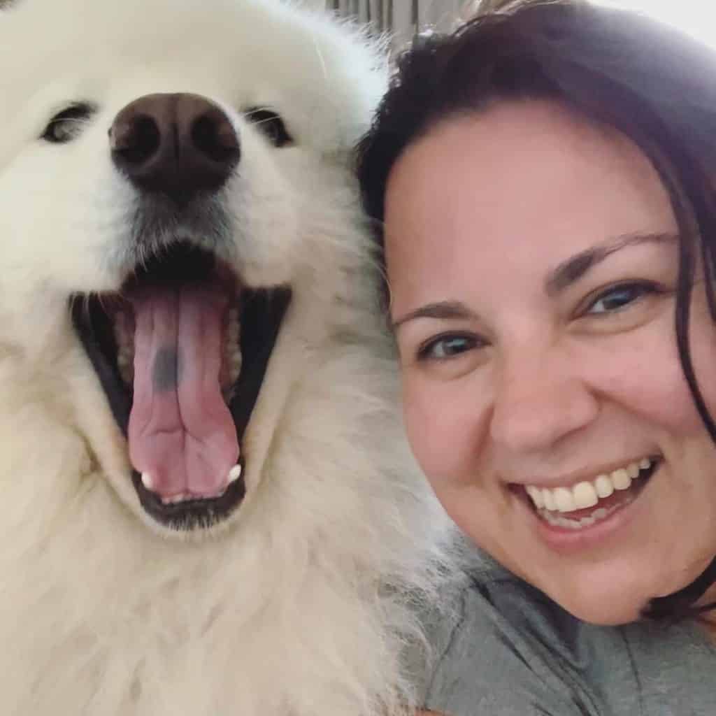 Emma Griffiths Voiceover smiling whilst with fluffy white dog yawning
